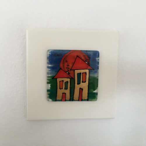 Billede af Håndlavet glasbillede med huse på hvid træplade 22 x 22 cm. Tilbud 250 kroner.